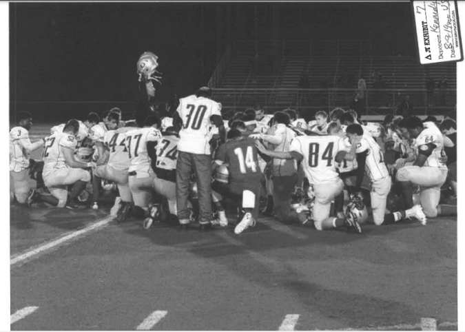 Entrenador Kennedy en oración